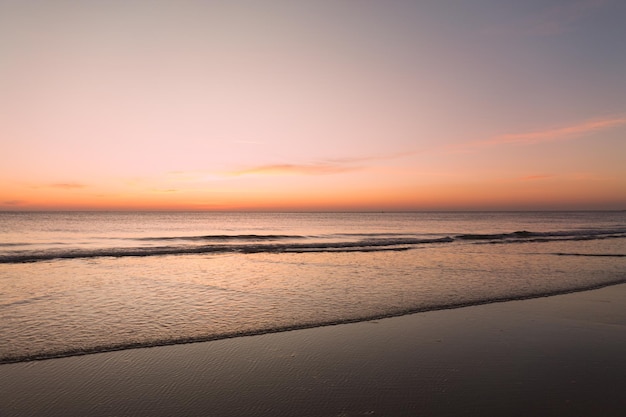 Mar calmo com céu pôr do sol com nuvem