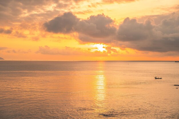 Mar calmo com céu pôr do sol e sol através das nuvens sobre Mar calmo com céu pôr do sol e sol através das nuvens sobre fundo de oceano e céu de meditação Paisagem marinha tranquila Horizonte sobre a água