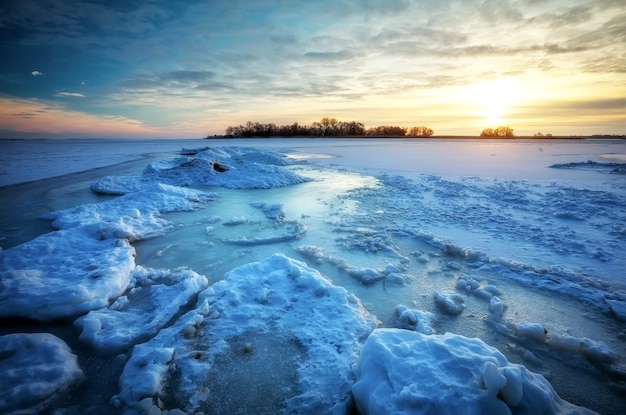 Mar congelado durante la puesta de sol. Hermoso paisaje marino natural en invierno