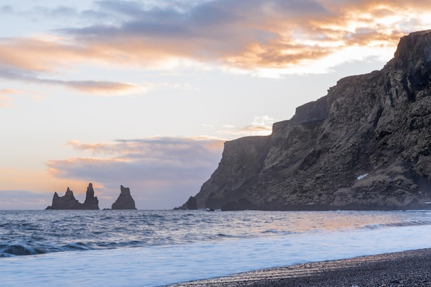 Mar de Reynisdrangar Stacks na praia de Vik na Islândia ao pôr do sol