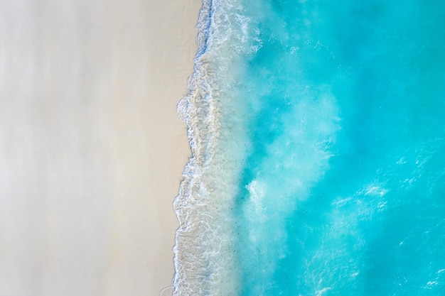 Mar de verão belas ondas, água do mar azul em dia ensolarado. Vista superior do drone. Vista aérea do mar,