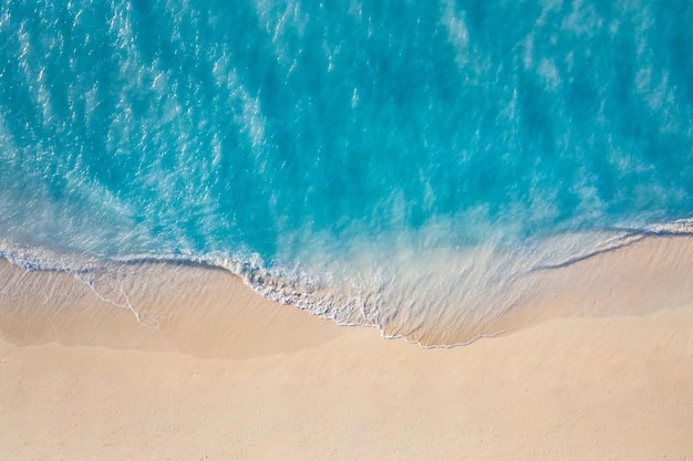 Mar de verão belas ondas, água do mar azul em dia ensolarado. Vista superior do drone. Vista aérea do mar