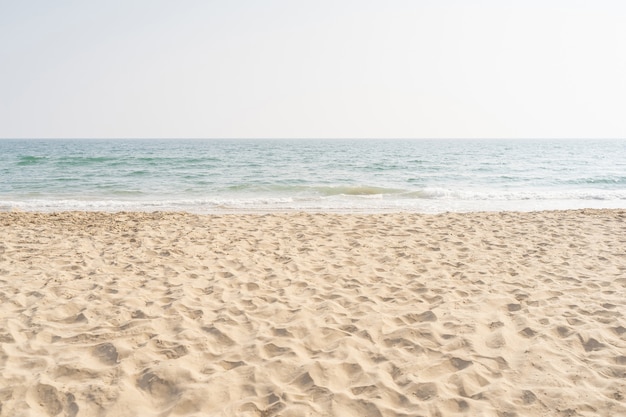 Foto mar e areia na praia tropical para segundo plano de férias.