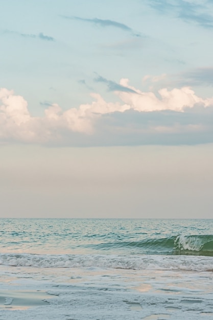 Mar e céu com nuvens no verão. Conceito de verão e férias. Ondas de cores azuis no mar.