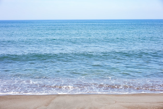 Mar e praia azuis em um dia ensolarado