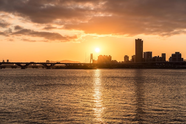 Mar por edificios contra el cielo durante la puesta de sol