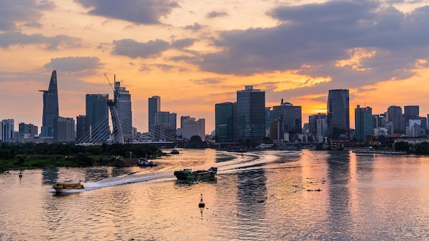 Mar por edificios modernos en el centro de la ciudad de Ho Chi Minh contra el cielo durante la puesta de sol