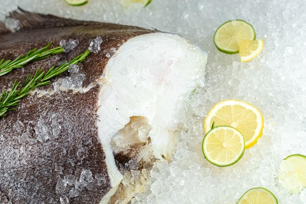 mar fresco oceano branco peixe inteiro, deitado no gelo, sem cabeça, cereja, fatias de limão e lima são