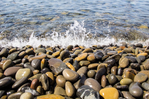 Mar y guijarros bajo el agua en una playa. Fondo de guijarros