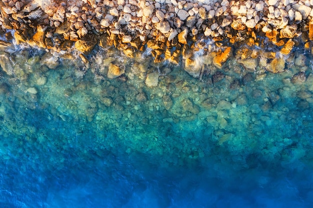 Mar Mediterrâneo Vista aérea sobre a água e rochas durante o pôr do sol Férias e aventura Praia e água azul Vista superior do drone na praia e mar azul