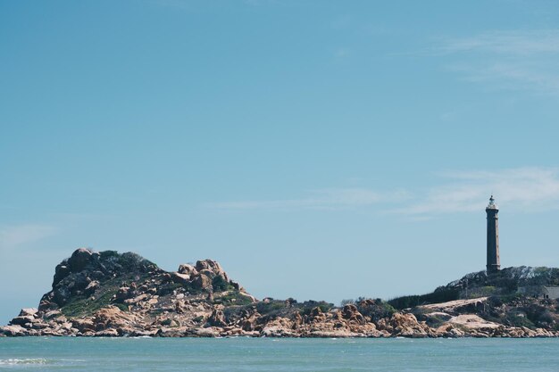 Mar natureza vista panorâmica paisagem fundo Oceano falésias rochosas ilha arborizada Céu azul claro Farol no topo da montanha Sinal avisar marinheiros naufrágio conceito de viagem esperança propósito da vida