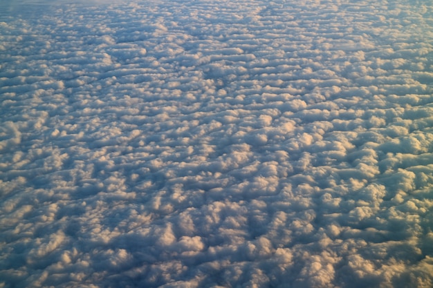 Mar de nubes en la luz del sol, impresionantes vistas desde el avión durante el vuelo