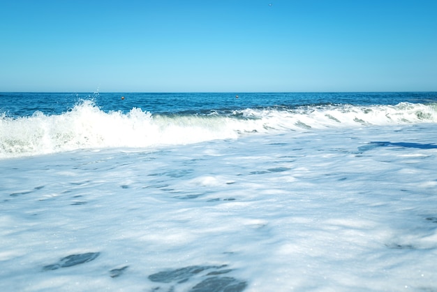 Foto mar, ola azul mar con espuma. sensación de calma, frescura, relajación. la idea de fondo frío y espacio de copia en la parte superior.