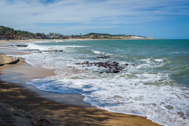 Mar con olas y dunas en Praia do Sagi Baia Formosa, cerca de Natal, en el estado de Rio Grande do Norte, Brasil