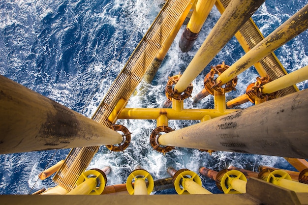 Mar de olas de tubería de perforación de tubería costa afuera amarillo y producción de gas oleoducto de petróleo.