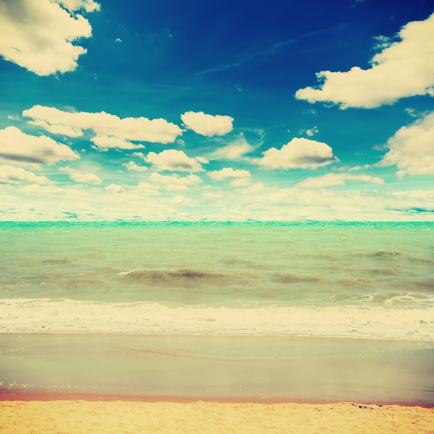 mar de la playa de arena y nubes de cielo azul con tono vintage.