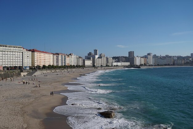 Mar por edifícios contra o céu azul claro em uma coronha galiza Espanha