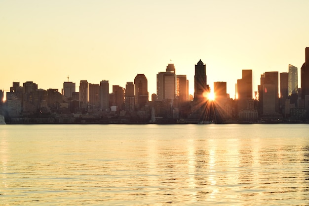 Mar por edifícios contra o céu claro durante o pôr-do-sol