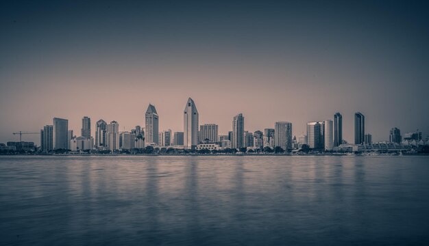 Foto mar por edifícios modernos contra o céu durante o pôr do sol