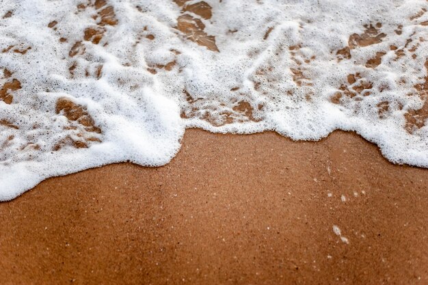 Mar, praia, areia, onda, verão, conceito de plano de fundo. Ondas brancas em uma praia de areia no verão, no pôr do sol. Conceito de fundo do mar.