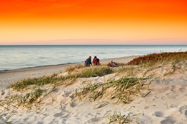 Mar puesta de sol. Joven pareja en una playa al atardecer. Romántico