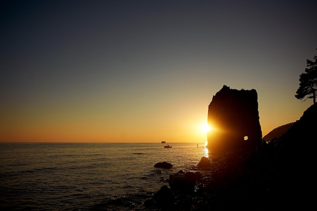 Mar puesta de sol lejos agua piedras roca