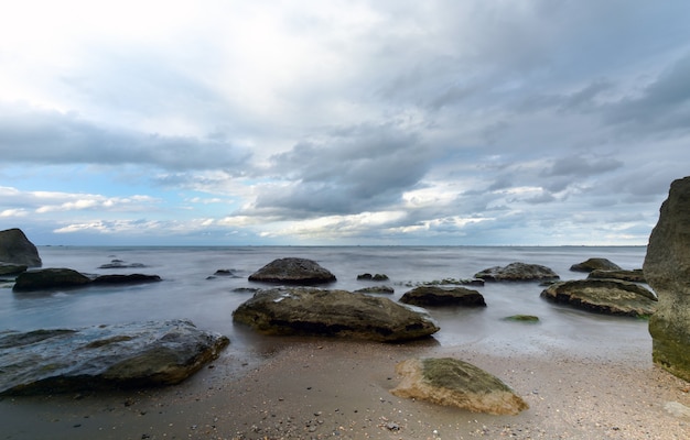 Mar tempestuoso e costa rochosa lindo céu dramático