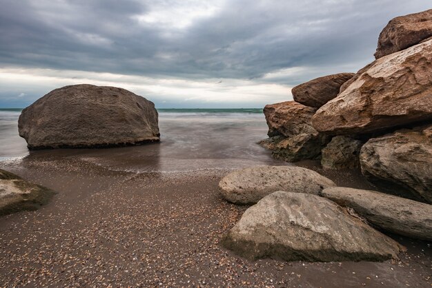 Mar tempestuoso e costa rochosa lindo céu dramático