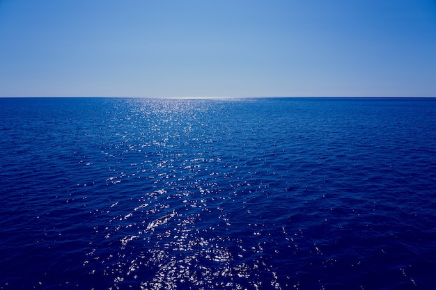 El mar traspasa el horizonte con un cielo azul de fondo.