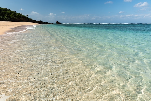 Mar turquesa deslumbrante translúcido com uma textura ondulada cobrindo as areias de coral. Ilha de Iriomote.