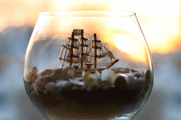 Foto mar viejo barco en una botella y una copa de vino.