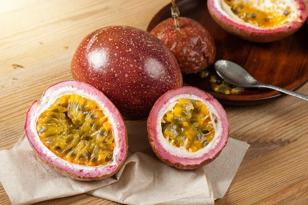 Maracuyá fresca sobre fondo de madera. La fruta de la pasión contiene muchas semillas negras pequeñas cubiertas con la pulpa de la fruta.