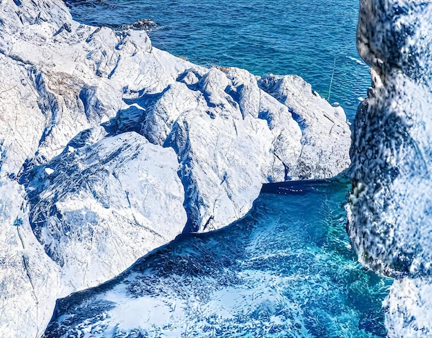 Maravilhas do inverno e paisagem de fantasia de Natal congelada costa do mar e montanhas cobertas de neve.