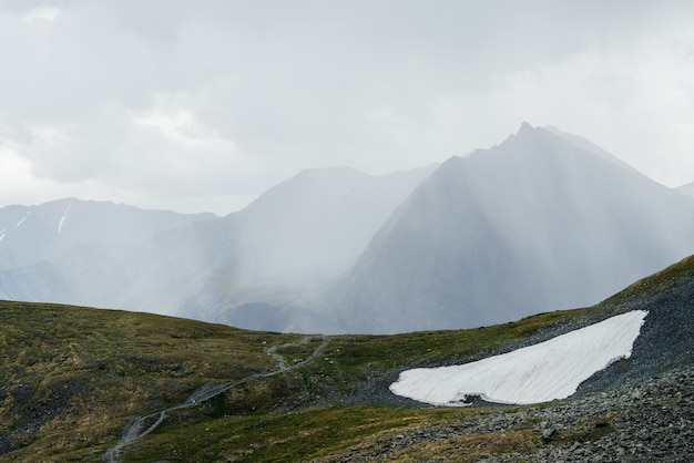 Foto maravilhosa paisagem alpina com montanha gigante com pináculo pontiagudo na luz do sol através das nuvens.