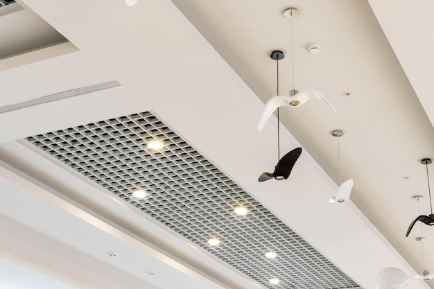 Maravillosa iluminación inusual y techo de diseño de un edificio moderno Techo blanco con sistema de ventilación en el centro comercial Diseño de interiores