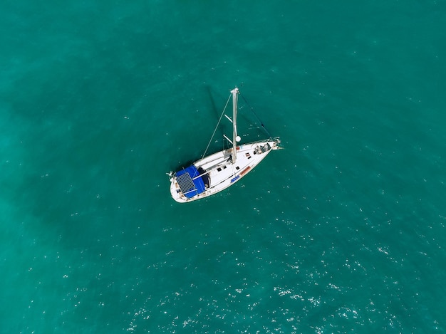 Maravillosa vista aérea de un enorme yate blanco y azul navegando por la laguna azul