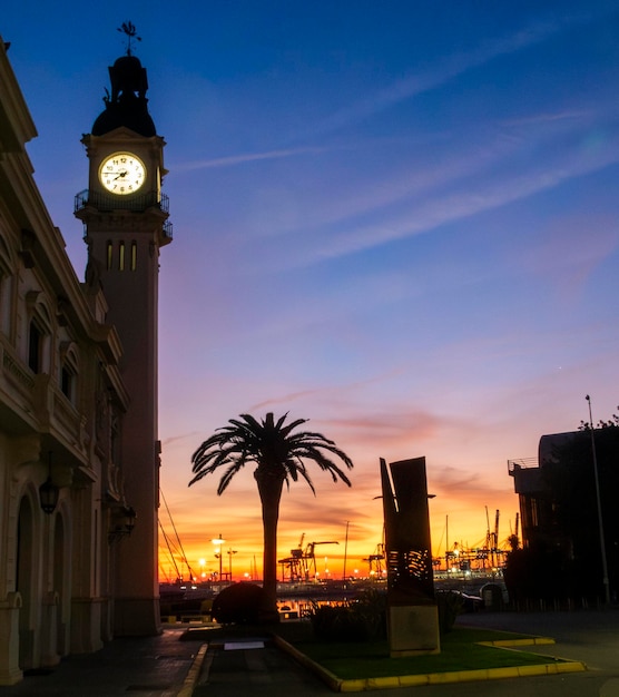 Maravilloso amanecer con el reloj del puerto de Valencia en primer plano iluminando España