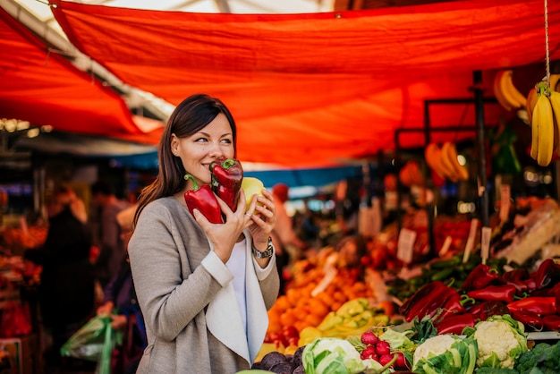 Maravilloso olor a verduras frescas. Hermosa mujer en el mercado de los agricultores.