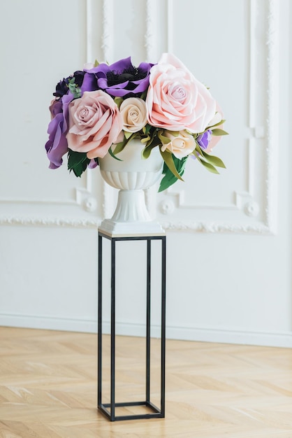 Maravilloso ramo de rosas rosadas y amapola morada en un elegante jarrón blanco sobre fondo blanco Evento festivo Decoración con flores