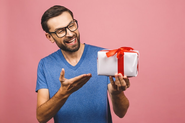 Maravilloso regalo! Adorable foto de hombre atractivo con hermosa sonrisa sosteniendo su caja de regalo de cumpleaños