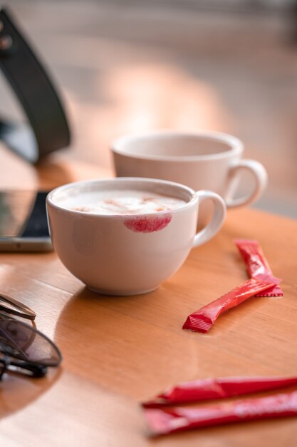 Foto marca de lápiz labial rojo en una taza de café sobre la mesa de café