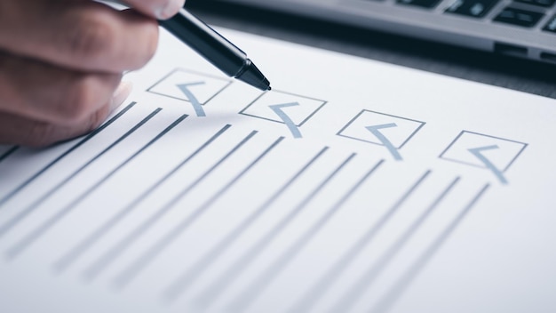Marca de verificación de la mano humana en el papelConcepto de verificación a través de casillas de verificaciónEncuestas a través de cuestionariosComentarios para liderar Desarrollar y solucionar erroresMarcación en la lista de verificación