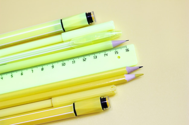 Marcadores amarelos, régua e lápis amarelos. de volta à escola. artigos de papelaria em fundo amarelo.