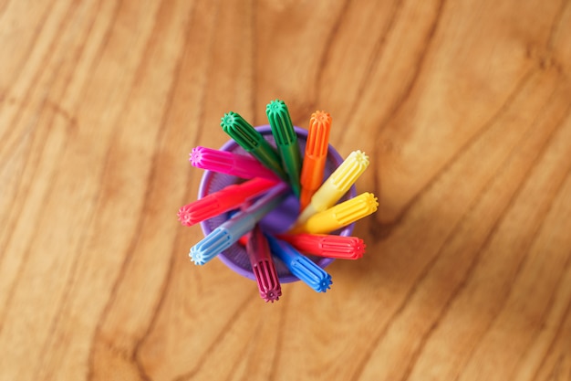 Marcadores de colores dentro de una canasta de bolígrafos