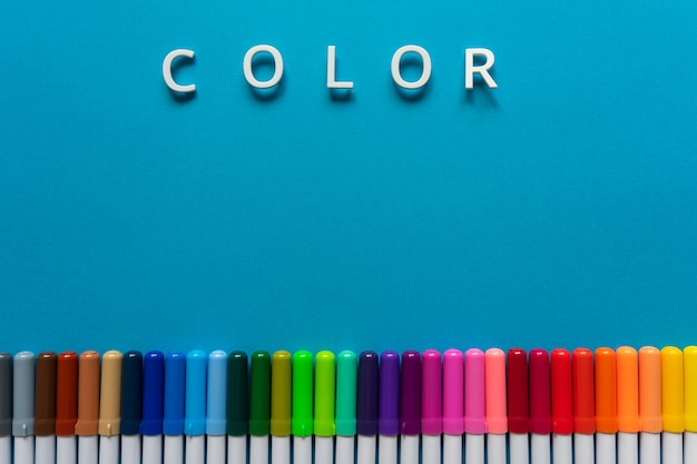 Foto marcadores de colores y la palabra color sobre un fondo azul.