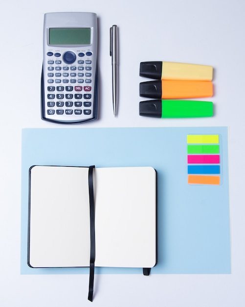 Marcadores coloridos, caneta, marcadores, calculadora e papel em branco para trabalhar ou estudar