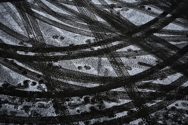 Marcas de pneus na estrada de neve, textura de estrada de inverno, gelo, fundo de perigo de transporte motorizado