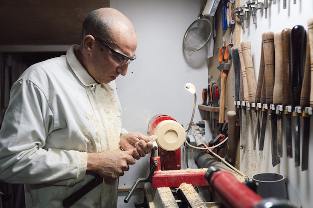 Marceneiro moldando um pedaço de madeira no torno