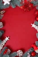 Foto marco de adornos navideños sobre un fondo rojo con espacio de copia