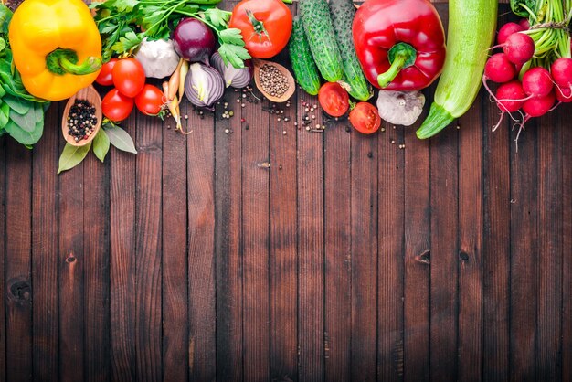 Marco de alimentos orgánicos Verduras crudas frescas y especias En una pizarra de madera